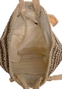 Vävd halmhandväska med ljusbruna och krämfärgade ränder, foder av bomullstyg och knappstängning. Insidan har en mjuk yta.