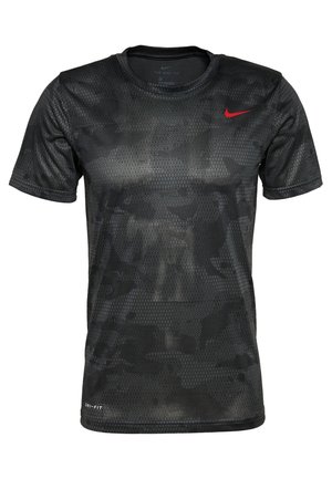 T-shirt noir à manches courtes Nike Dri-FIT avec un discret motif camouflage hexagonal et un petit logo rouge Nike Swoosh sur la poitrine.