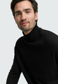 Schwarzer Rollkragenpullover aus Strickstoff, mit einem figurbetonten Schnitt und geripptem Kragen, mit einer glatten Textur.