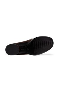 Chaussure en cuir marron avec une semelle en caoutchouc noir. La semelle présente des nervures horizontales pour une meilleure adhérence et a une finition lisse avec une forme arrondie.