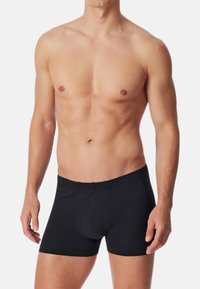 Schwarze Baumwoll-Boxershorts mit elastischem Bund, ausgestattet mit einer konturierten Tasche und einem maßgeschneiderten Design, das eine optimale Passform bietet.