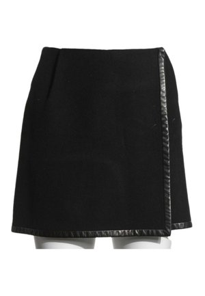 Mini-jupe noire avec bordure en cuir le long de l'ourlet et du bord avant croisé, exposée sur un mannequin blanc.