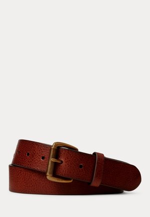 Ceinture en cuir marron texturé avec une boucle rectangulaire en laiton, roulée et posée sur un fond clair uni.