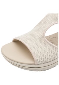 Sandal aperto con tomaia in tessuto cremoso texture, soletta beige liscia e suola flessibile con un sottile motivo a rilievo.