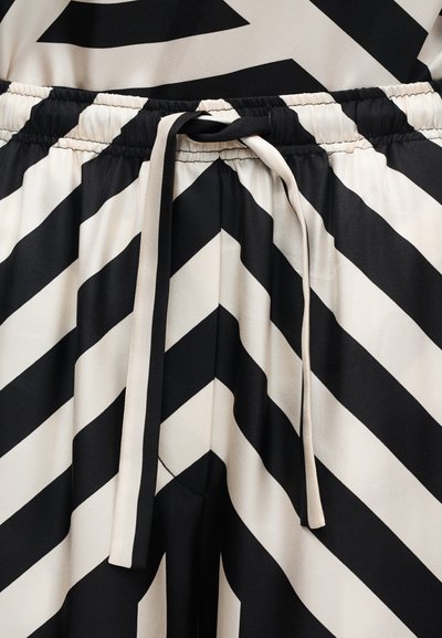 Ύφασμα με μαύρες και λευκές διαγώνιες ρίγες, με σούρα ελαστική μέση και δεμένη κορδέλα με ρίγες στην μέση.