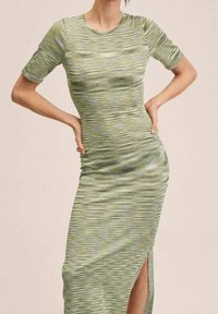 Abito verde a righe con maniche corte, taglio slim, tessuto morbido, spacco laterale e scollo rotondo.