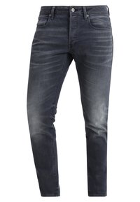 Mörkblå denimjeans med slim fit, med en blekt yta och subtila slitningar, avslutade med en standard dragkedja och knappstängning.