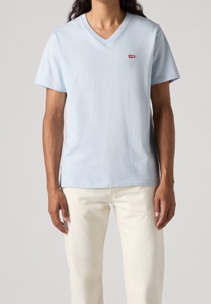 Helles blaues V-Ausschnitt-T-Shirt aus Baumwolle, mit kurzen Ärmeln, featuring einem kleinen roten Levi's-Logo auf der linken Brustseite. Einfaches Design.