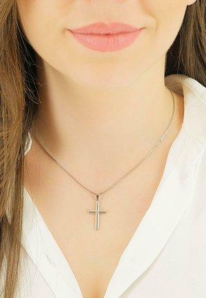 Silberne Kreuzanhänger-Halskette an einer dünnen Kette, getragen über einem weißen Hemd. Glatte Oberfläche mit minimalistischem Design.