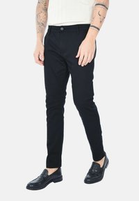 Pantaloni slim fit neri realizzati in misto cotone, con chiusura a bottone, tasche frontali e dettagli di cucitura minimi. Abbinare a mocassini neri.
