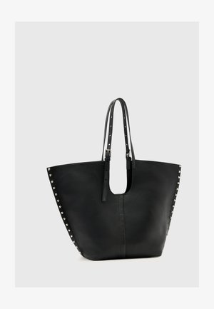 Zwarte leren tote bag met een brede opening, studaccenten aan de zijkanten en twee verstelbare banden voor het dragen.