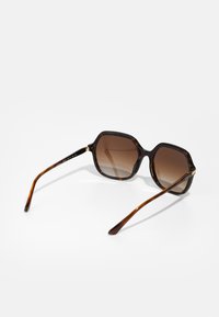 Ochelari de soare cu gradient maro și ramă octagonală. Fabricată din material de broască țestoasă, având brațe elegante cu un accent de aur.