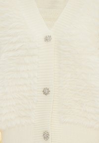 Cardigan avorio con un davanti testurizzato e soffice e maniche a coste. Cinque bottoni decorativi in tono argento abbelliscono la parte anteriore.