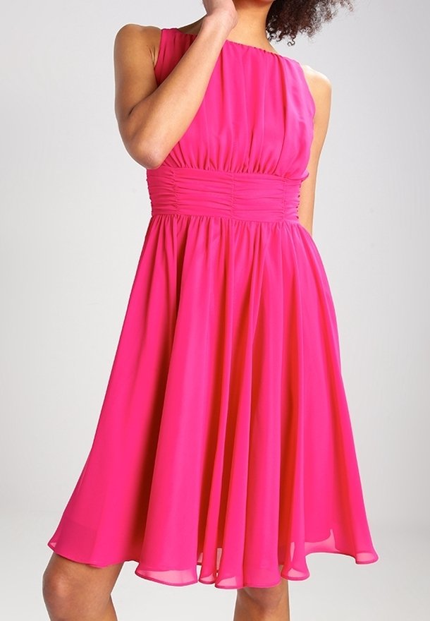 Femme portant une robe sans manches rose vif longueur genou avec une taille froncée et une jupe fluide sur un fond uni.