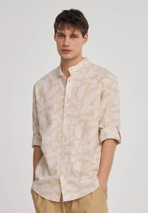 Camicia beige con bottoni, a maniche lunghe arrotolate, con motivo di foglie di palma bianche, texture morbida, colletto a punta, design slim fit.