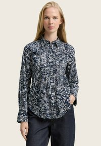 Marineblaues Hemd mit Knöpfen, weißem abstraktem Muster, langen Ärmeln und abgerundetem Saum. Hergestellt aus weichem Stoff, verfügt es über einen klassischen Kragen und Taschen.