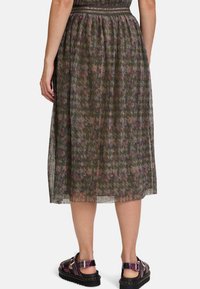 Plissé midi rok in donkergroen met een bloemenpatroon in roze en blauwe tinten, met een aansluitende tailleband en gelaagde textuur. Draag het met chunky sandalen.