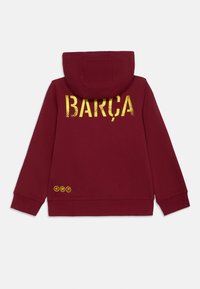 Μαρόνο hoodie με κουκούλα, που διαθέτει μεγάλο κίτρινο κείμενο "BARÇA" στο πίσω μέρος, με τρεις κίτρινες διακοσμητικές κύκλους στο τελείωμα. Συνθετικό ύφασμα από βαμβάκι.