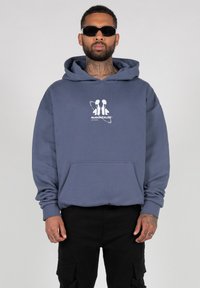 Hooded sweatshirt in dark blue, cotton, featuring a front pocket and white graphic logo on chest. Long sleeves with ribbed cuffs.
