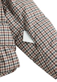 Višebojni uzorak posteljine s dijamantnim dizajnom u crvenoj, plavoj i krem nijansi. Tekstura tkanine izgleda mekano s pamučnim finišem.