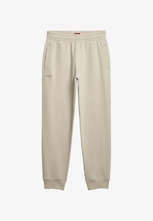 Beige Sweatpants mit weicher Textur, elastischem Bund, zwei Seitentaschen und aufgesticktem Logo-Detail am linken Oberschenkel.