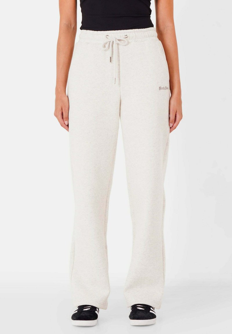 Hellgraue Sweatpants mit einem Kordelzugbund, lockerer Passform, weicher Textur und kleinem gesticktem Logo an der Seite.