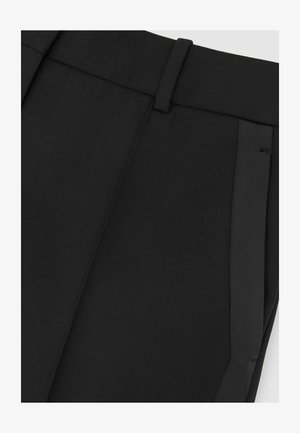 Artimųjų planų juodos pritaikytos kelnės su diržo kilpomis ir paslėptu šoniniu kišeniu.