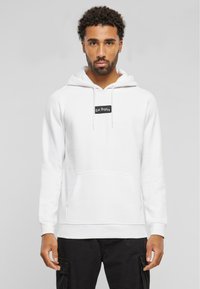 Hoodie blanc avec poche avant et patch noir "Los Angeles". Caractérisé par des cordons à capuche et des poignets côtelés ; texture en coton lisse.