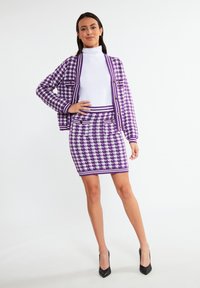 Paarse en witte herringbone gebreide cardigan en rok set, met een aansluitend ontwerp, lange mouwen en accentknopen.