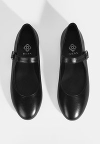 Schwarze Leder-Mary-Jane-Schuhe mit einer abgerundeten Zehenpartie, einem glänzenden Riemen mit Schnalle und einer glatten Textur. Logo auf der Innensohle sichtbar.