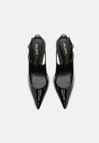 Musta kiiltonahkainen slingback-kengät, joissa on terävä nenä, leikattu muotoilu ja säädettävä nilkkahihna, jossa on kultainen yksityiskohta.
