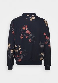 Chaqueta bomber floral en tejido azul marino oscuro. Presenta patrones de flores coloridos en rosa, amarillo y verde, con un dobladillo y puños acanalados.