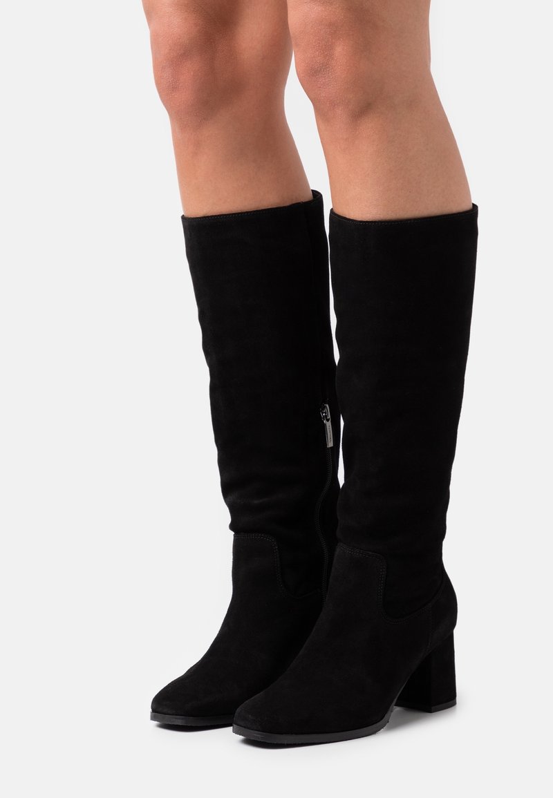 Bottes hautes jusqu'au genou en daim noir avec talon bloc, dotées d'une fermeture éclair latérale et d'une texture lisse. Le design comprend des accents cousus le long des coutures.