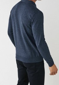 Marineblauer Strickpullover mit Rundhalsausschnitt, langen Ärmeln und gerippten Bündchen. Verfügt über einen strukturierten Stoff für visuelles Interesse.