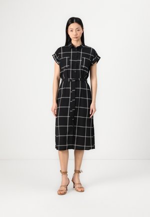 Robe noire à boutons avec motif à carreaux blancs, manches courtes, ceinture à la taille et longueur mi-mollet. Tissu lisse et silhouette ajustée.