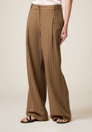 Pantaloni larghi a righe marroni con pieghe frontali, dotati di vita con passanti per cintura e chiusura con bottone metallico.