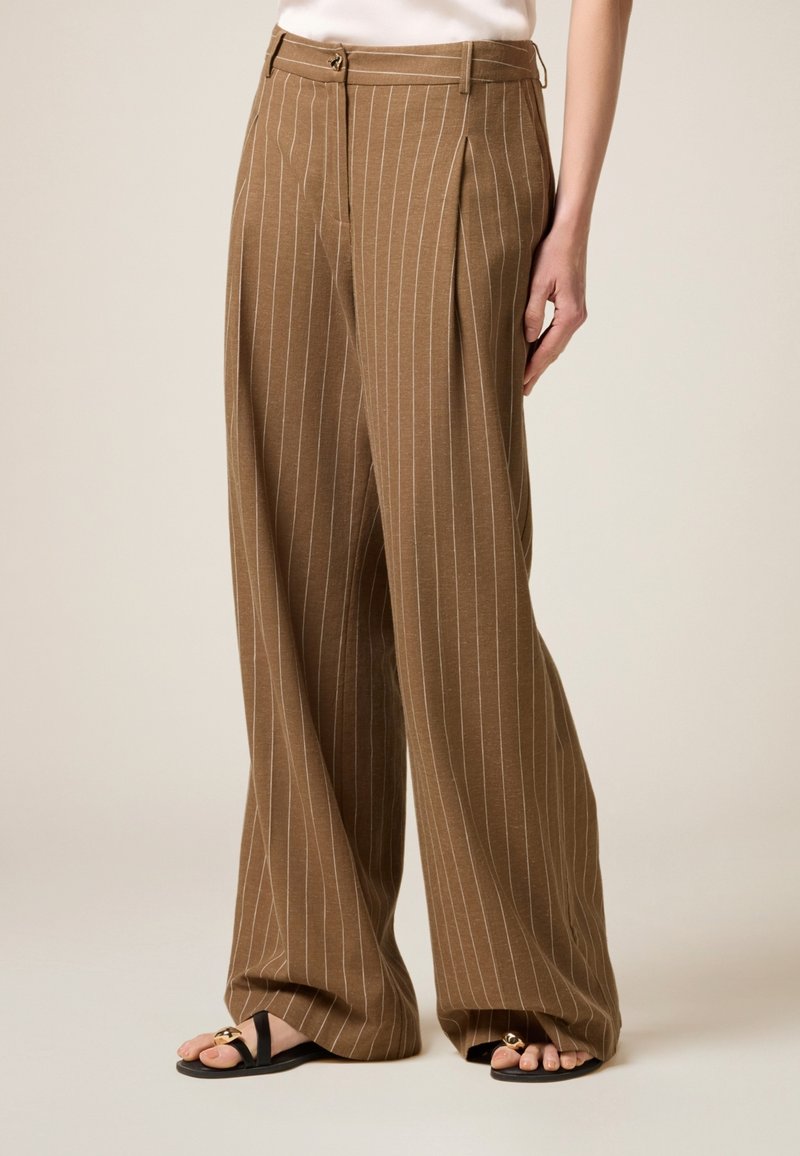 Bruna strimmiga vida byxor med framveck, med midja med bältesöglor och metallknappsstängning.