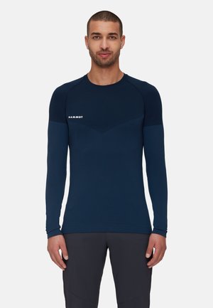 Marineblauw sportshirt met lange mouwen en ronde hals, met een aansluitend ontwerp, contrasterende texturen op de schouders en een wit logo op de borst.
