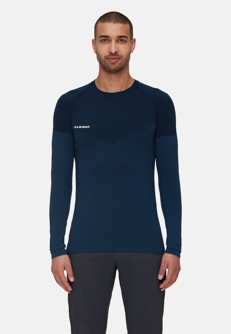 Marinblå långärmad prestationsskjorta med rund halsringning, med en åtsittande design, kontrasterande texturer på axlarna och vit logotyp på bröstet.