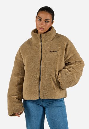 Braune Fleece-Jacke mit Reißverschluss, hohem Kragen, oversized Schnitt und zwei Seitentaschen. Verfügt über strukturierten Stoff und minimale Markenkennzeichnung auf der Brust.