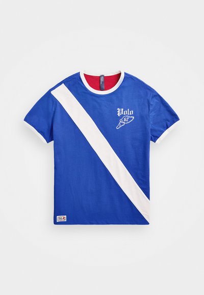 Blue cotton t-shirt featuring a white diagonal stripe, round neck with a red interior, and "Polo 67" logo in white on the front.