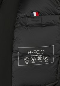 Zwarte geïsoleerde jas met een interieur dat het H-ECO Repreve vullabel toont, met vermelding van gerecycleerde, duurzame, milieuvriendelijke en waterafstotende eigenschappen.
