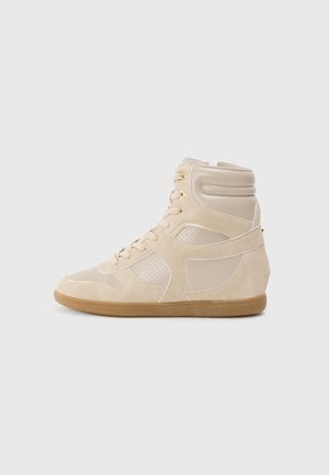 Beige høyhælte sneakers som har glatte lær- og semskede materialer. Perforerte paneler, tonal søm og gummisåle.