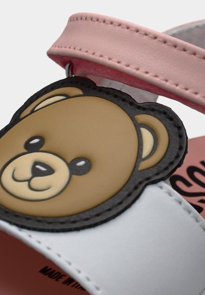 Παιδικό σανδάλι ροζ και λευκό με διακόσμηση από καφέ αρκουδάκι στο λουράκι.