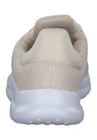 Chaussure de sport beige avec une tige en maille texturée, un col rembourré, et une semelle en caoutchouc blanc dotée de rainures de traction.