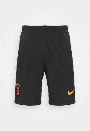 Zwarte sportieve korte broek van lichtgewicht materiaal met een elastische tailleband. Gele Nike-logo en geborduurd teamembleem met sterren.
