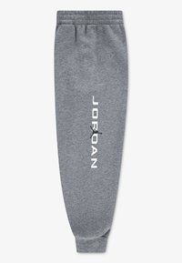 Pantalon de survêtement gris avec taille élastique, chevilles resserrées et texte blanc "JORDAN". Fabriqué en tissu doux avec une texture lisse.