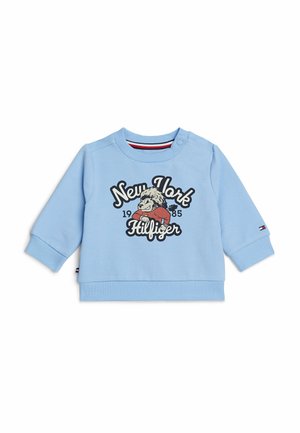 Sweatshirt azzurro chiaro con maniche lunghe, polsini e orlo a costine. Presenta una grafica frontale con la scritta "New York 1985 Hilfiger" insieme a un personaggio dei cartoni animati.