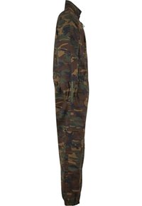 Zöld, barna és fekete álcázott munkaruha; jellemzője a magas gallér, rugalmas mandzsetták és több zseb a tároláshoz.