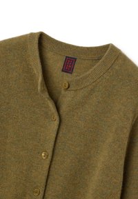 Cardigan verde oliva realizzato in tessuto testurizzato, con colletto rotondo, tre bottoni e un'etichetta con testo rosso e nero.